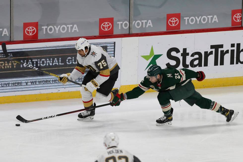 Minnesota Wild's Carson Soucy (21) tries to knock the puck away from Vegas Golden Knights' Ryan ...