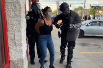 Police officers are shown arresting Des Moines Register reporter Andrea Sahouri after a Black L ...