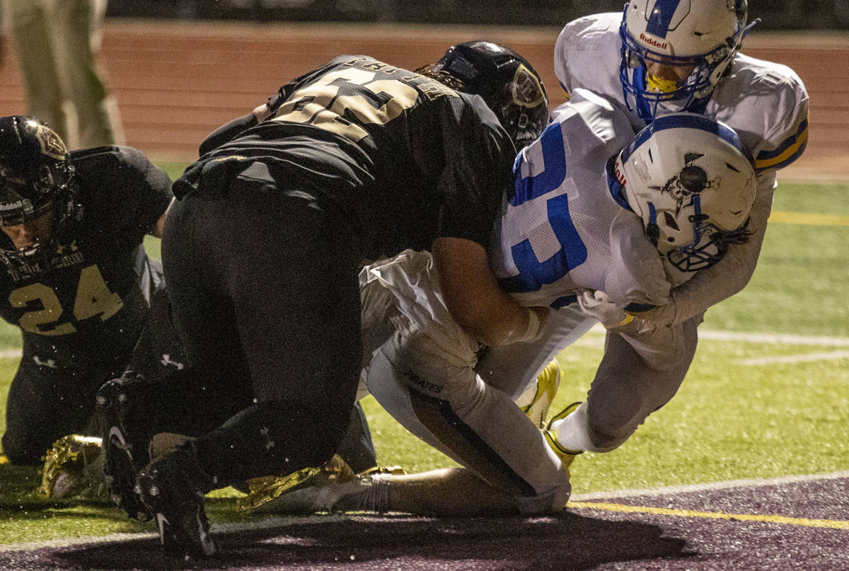 Moapa ValleyÕs Landon Wrzesinski (23) scores with Faith LutheranÕs Beau Graham (62) o ...