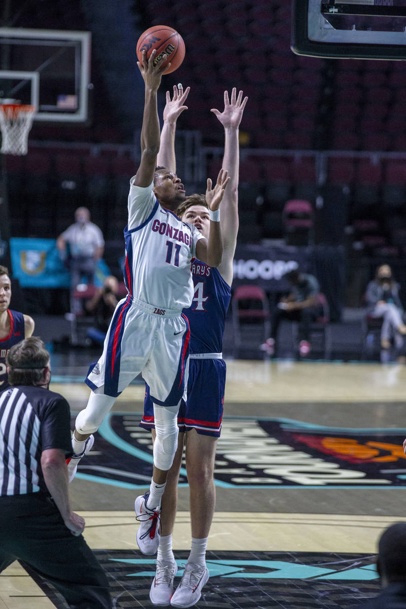 Gonzaga Bulldogs guard Joel Ayayi (11) leaps past St. Mary's Gaels forward Kyle Bowen (14) to m ...