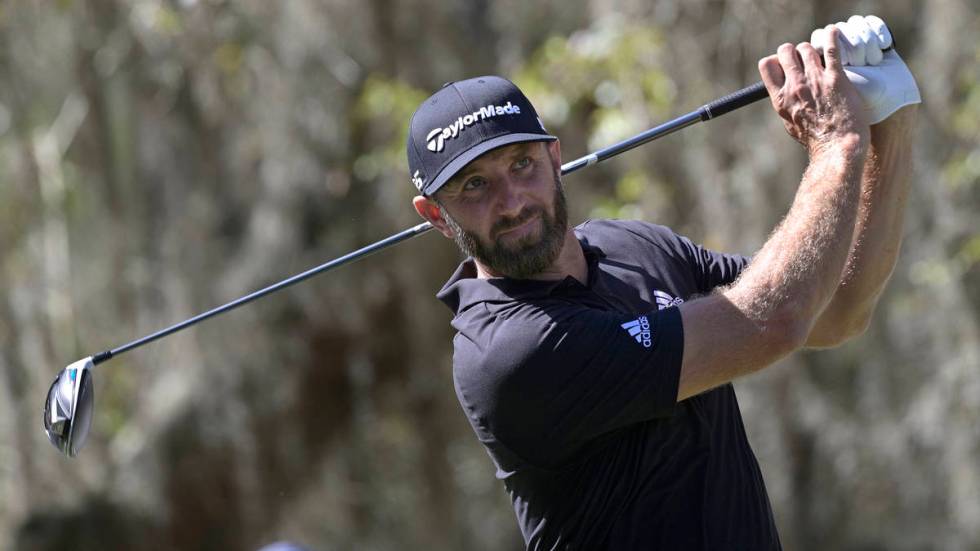 Dustin Johnson watches his tee shot on the ninth hole during the third round of the Workday Cha ...