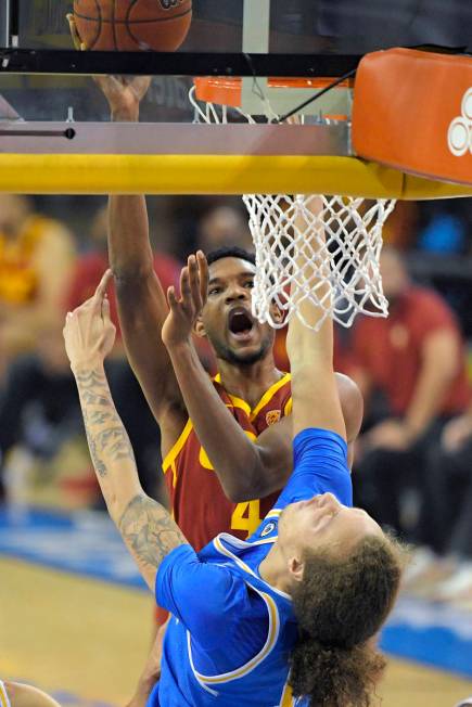 Southern California forward Evan Mobley, top, shoots as UCLA forward Mac Etienne defends during ...