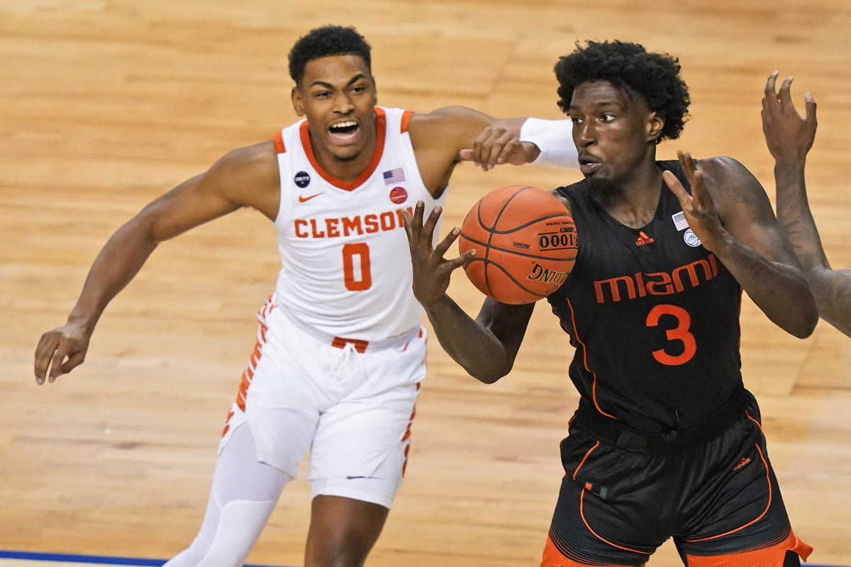 Miami center Nysier Brooks (3) tries to corral a rebound in front of Clemson guard Clyde Trapp ...