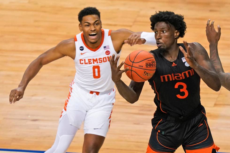 Miami center Nysier Brooks (3) tries to corral a rebound in front of Clemson guard Clyde Trapp ...