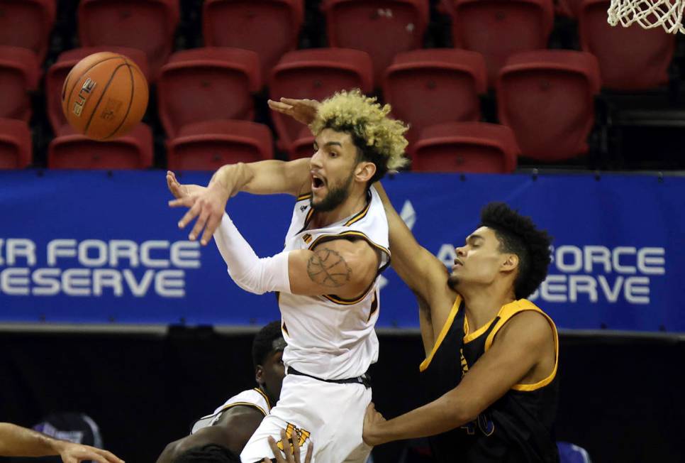 Wyoming guard Hunter Maldonado, left, passes as San Jose State forward Chase Courtney (40) defe ...