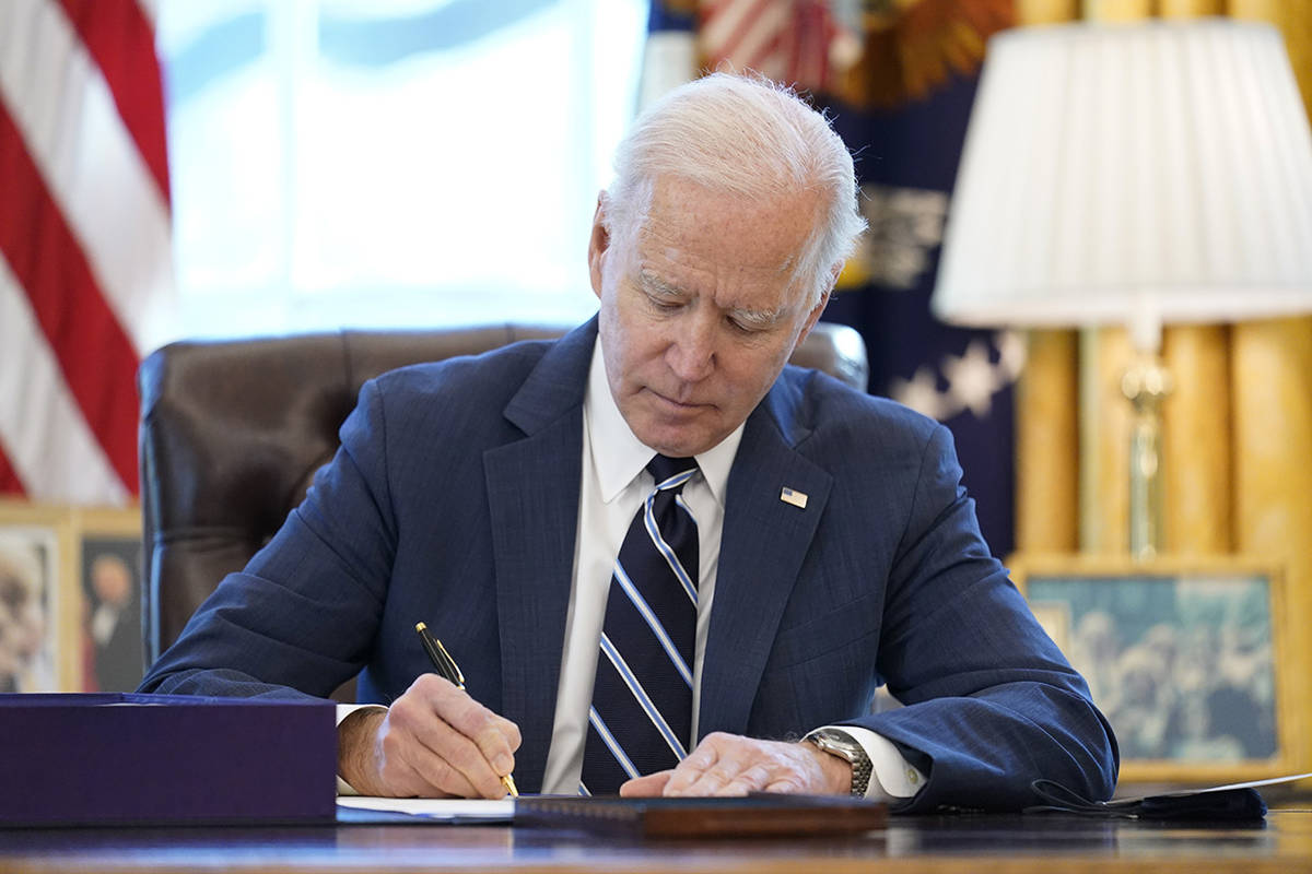 President Joe Biden signs the American Rescue Plan, a coronavirus relief package, in the Oval O ...