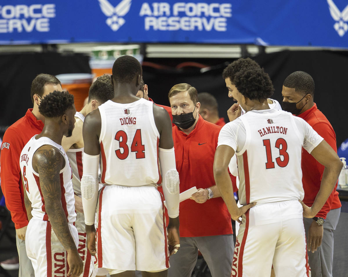 UNLV Rebels head coach T.J. Otzelberger, middle, draws up a play during a timeout in the first ...