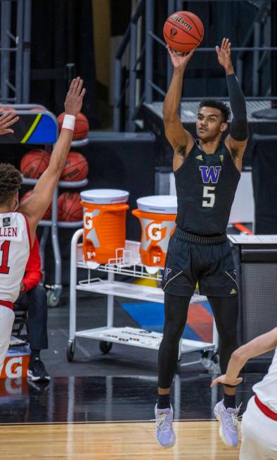 Washington Huskies guard Jamal Bey (5) gets off a three-point shot as Utah Utes forward Timmy A ...