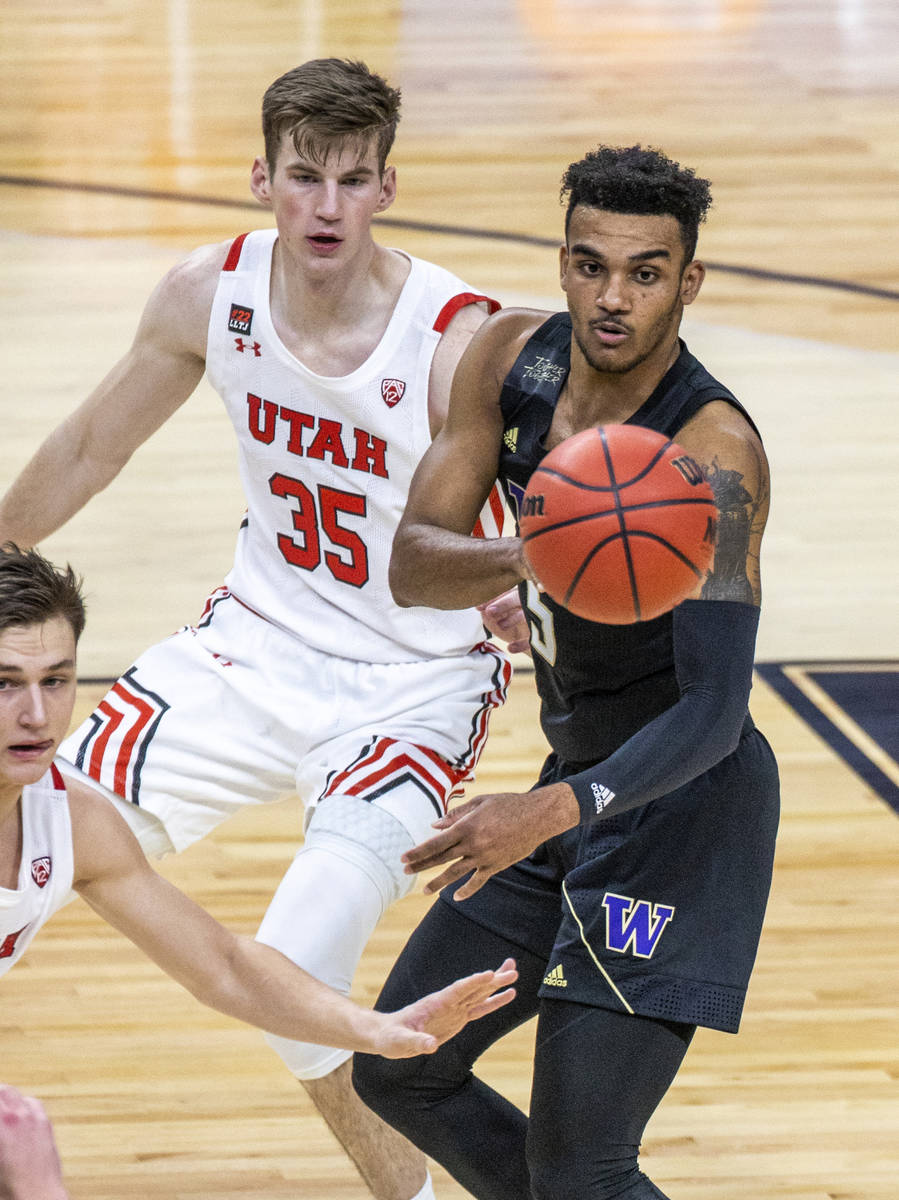 Washington Huskies guard Jamal Bey (5) gets off a pass with Utah Utes center Branden Carlson (3 ...