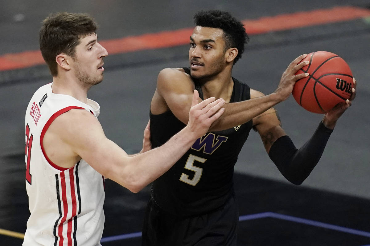 Washington's Jamal Bey (5) passes around Utah's Riley Battin (21) during the second half of an ...