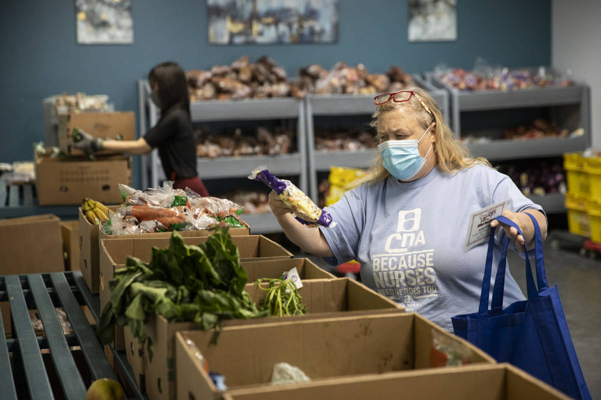 Roxann Putscher selects produce at the City Impact Urban Food Bank in Las Vegas, on Wednesday, ...