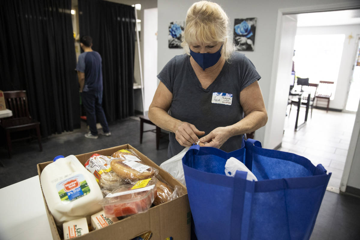 Volunteer Julie Presler puts together a box of food at the City Impact Urban Food Bank in Las V ...