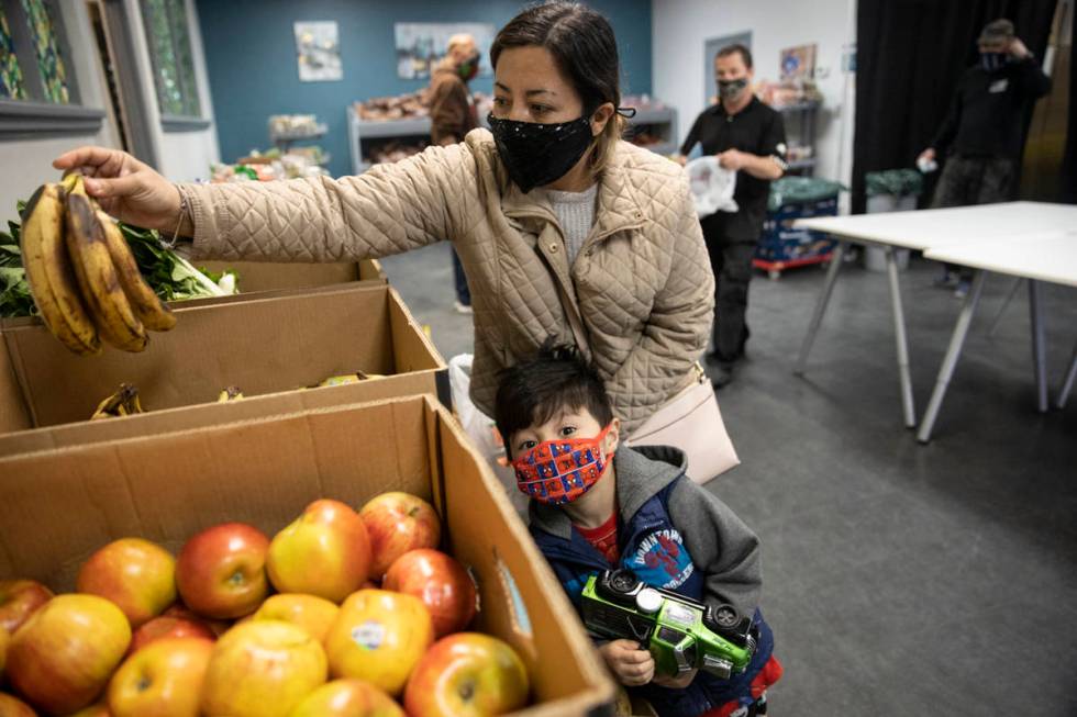 Yulissa Peña with her 4-year-old son Yadiel, selects bananas at the City Impact Urban Food ...