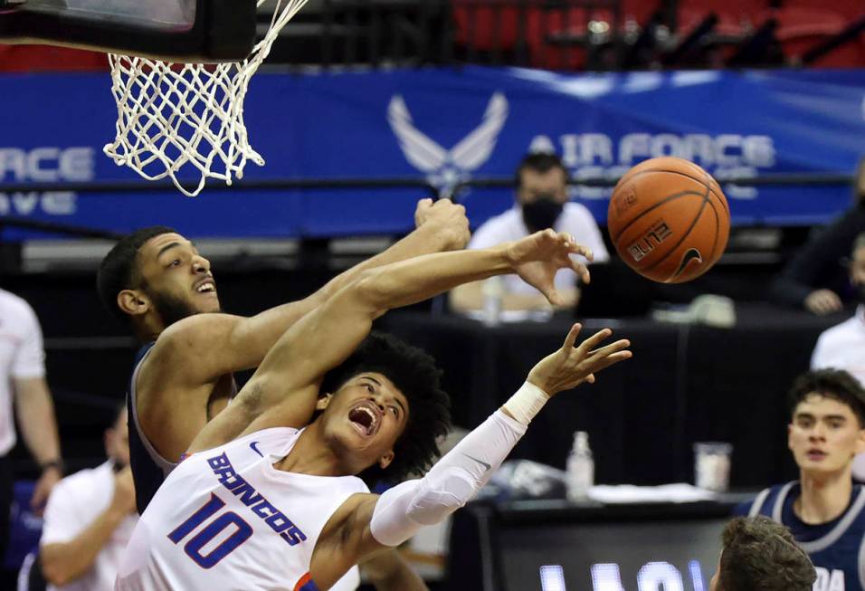 Nevada forward Robby Robinson, left, and Boise State guard RayJ Dennis (10) reach for a rebound ...