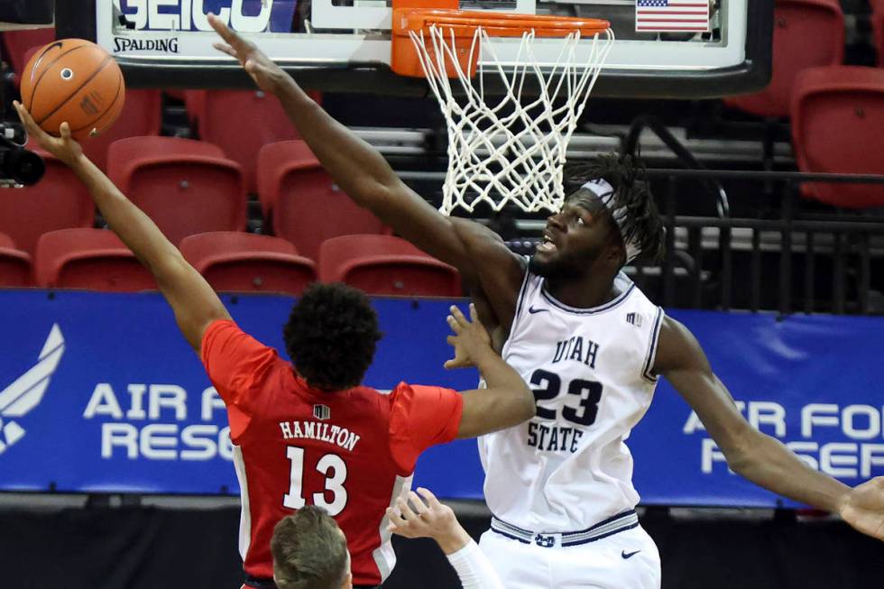 UNLV guard Bryce Hamilton (13) shoots as Utah State center Neemias Queta (23) defends during th ...