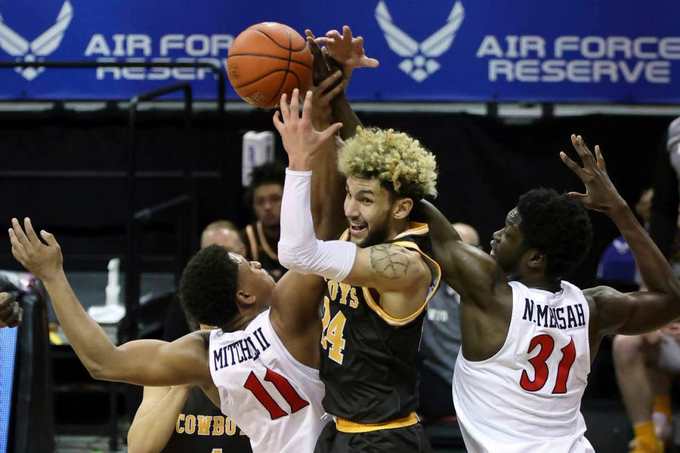 Wyoming guard Hunter Maldonado (24) reaches for a rebound with San Diego State forward Matt Mit ...