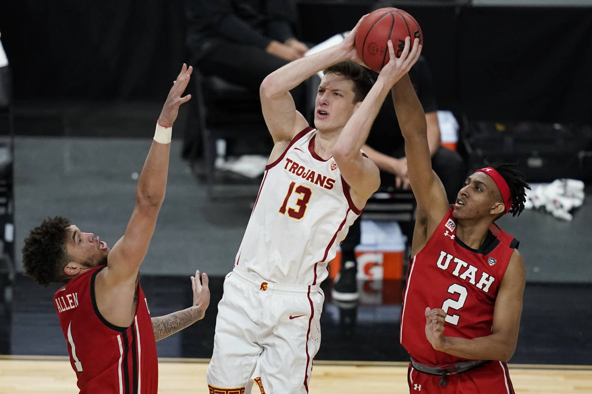 Southern California's Drew Peterson (13) shoots over Utah's Timmy Allen, left, and Ian Martinez ...