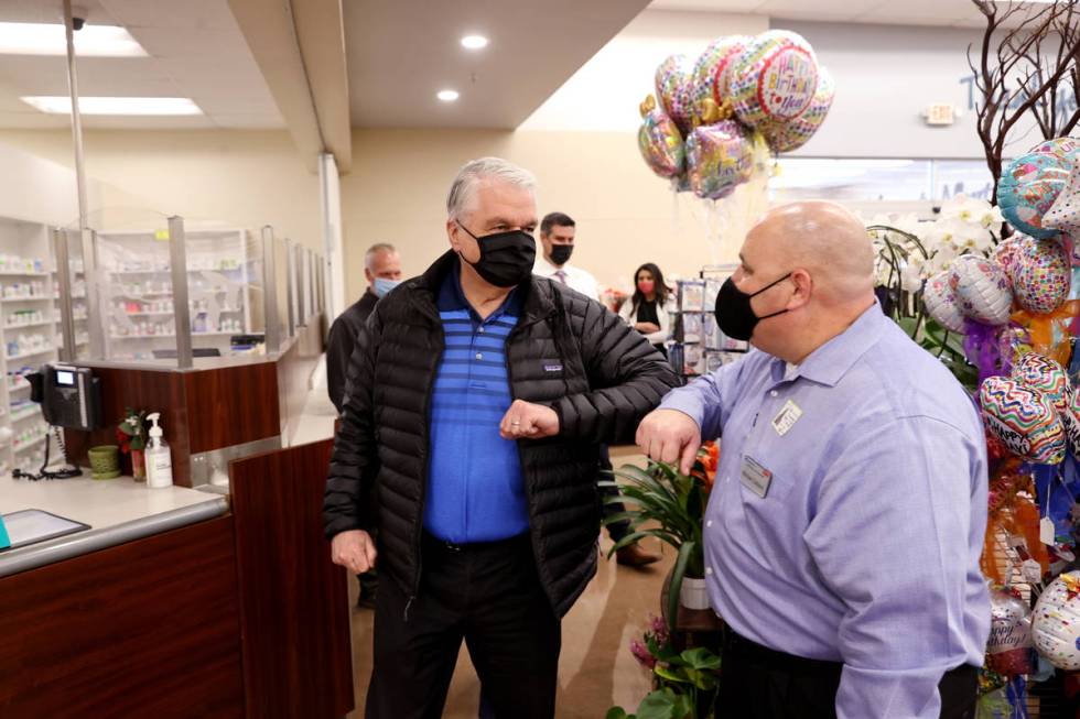 Gov. Steve Sisolak greets District Manager Michael Cefaloni before receiving his COVID-19 vacci ...