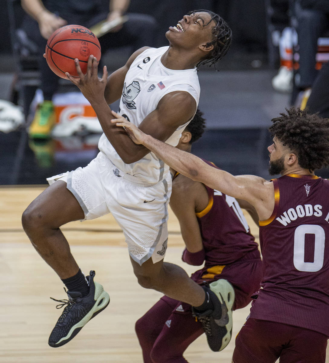 Oregon Ducks forward Eric Williams Jr., left, is fouled by Arizona State Sun Devils guard Holla ...