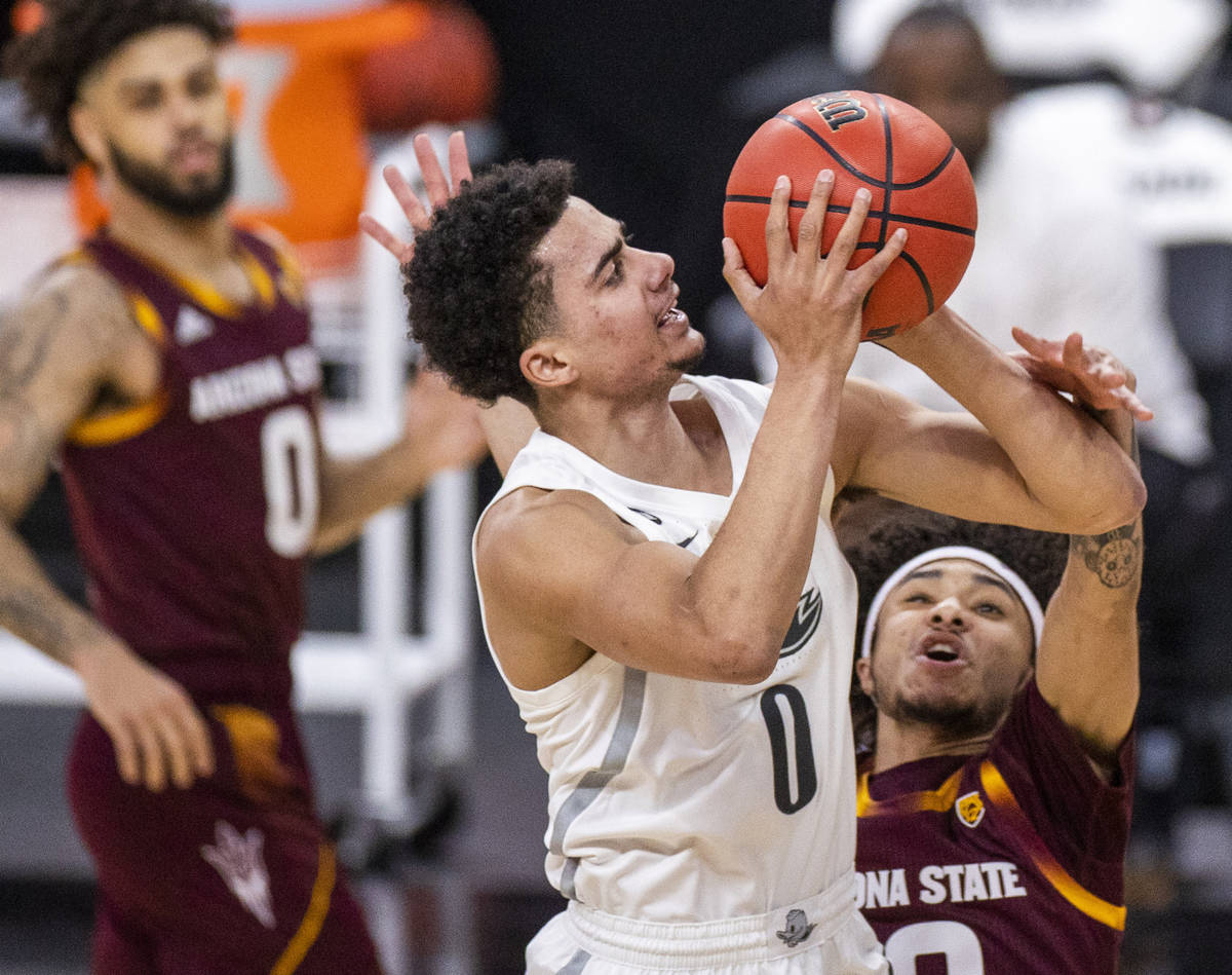 Oregon Ducks guard Will Richardson (0) fights off a foul from Arizona State Sun Devils guard Ja ...