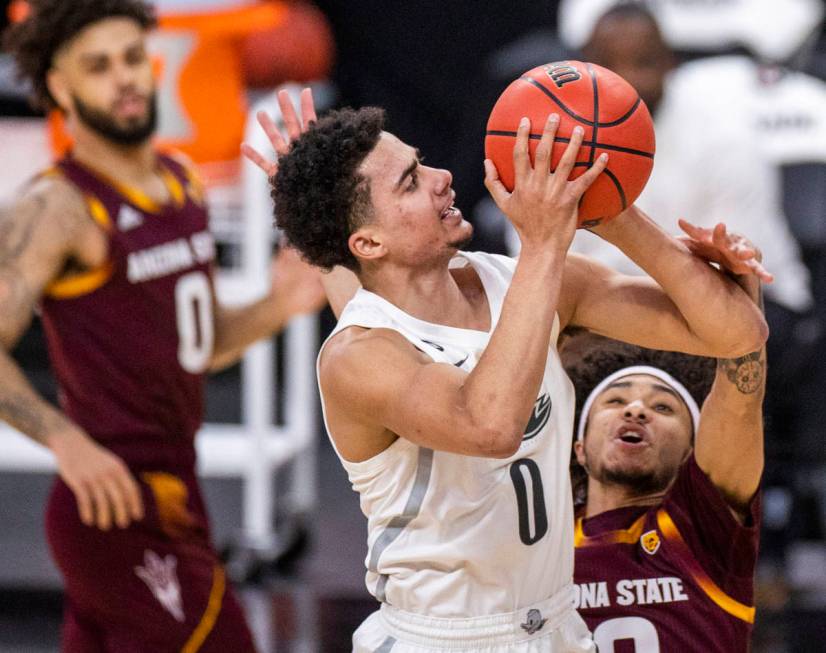 Oregon Ducks guard Will Richardson (0) fights off a foul from Arizona State Sun Devils guard Ja ...