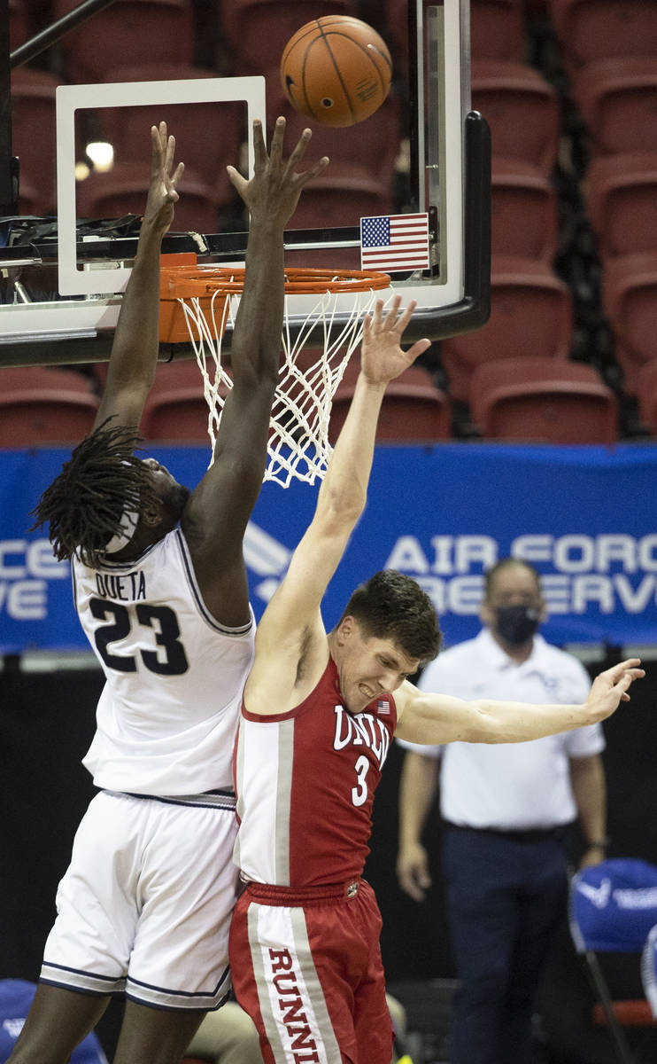 UNLV Rebels guard Caleb Grill (3) fights for a rebound with Utah State Aggies center Neemias Qu ...