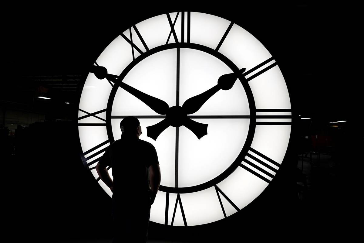 Electric Time technician Dan LaMoore admires a 1,000-lb., 12-foot diameter clock constructed fo ...