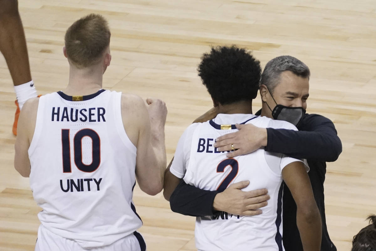 Virginia guard Reece Beekman (2) gets a hug from head coach Tony Bennett after sinking the game ...