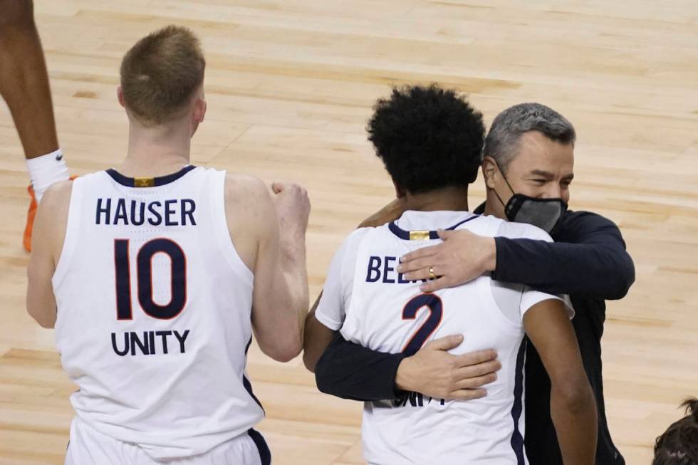 Virginia guard Reece Beekman (2) gets a hug from head coach Tony Bennett after sinking the game ...