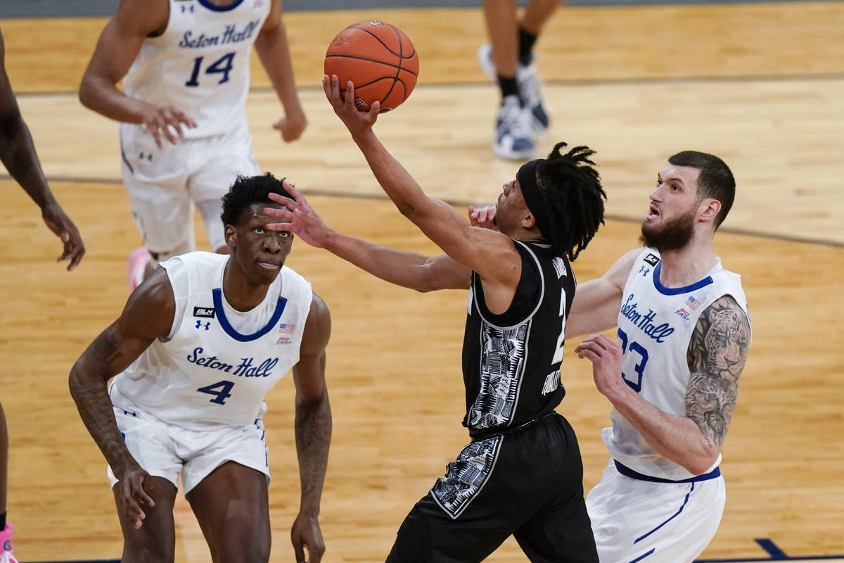 Georgetown's Dante Harris (2) drives past Seton Hall's Sandro Mamukelashvili (23) and Tyrese Sa ...