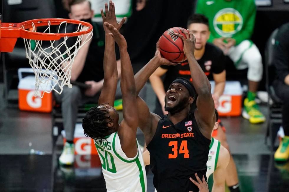 Oregon State's Rodrigue Andela (34) shoots over Oregon's Eric Williams Jr. (50) during the firs ...