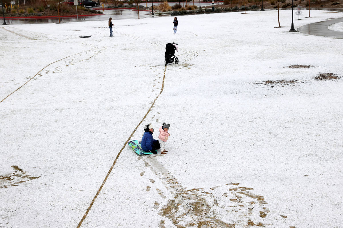 Landon Morris, 9, of Las Vegas, takes his sister Collins, 1, for a sled ride in the snow at Fox ...