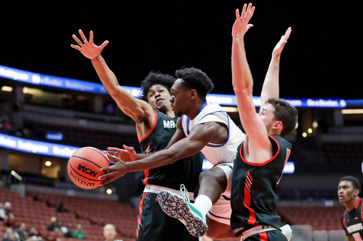 UC Santa Barbara guard Devearl Ramsey, passes between Cal State Northridge guard Rodney Henders ...