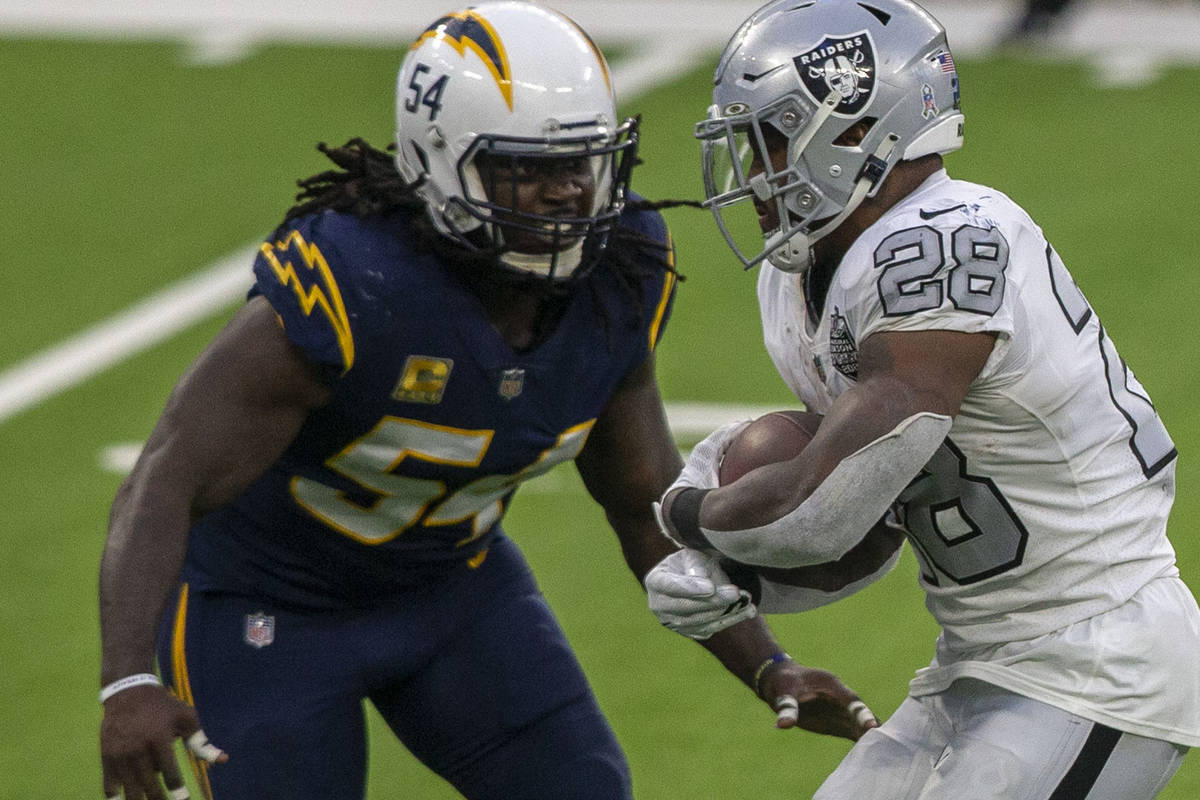 Las Vegas Raiders running back Josh Jacobs (28) tries to rush past Los Angeles Chargers defensi ...