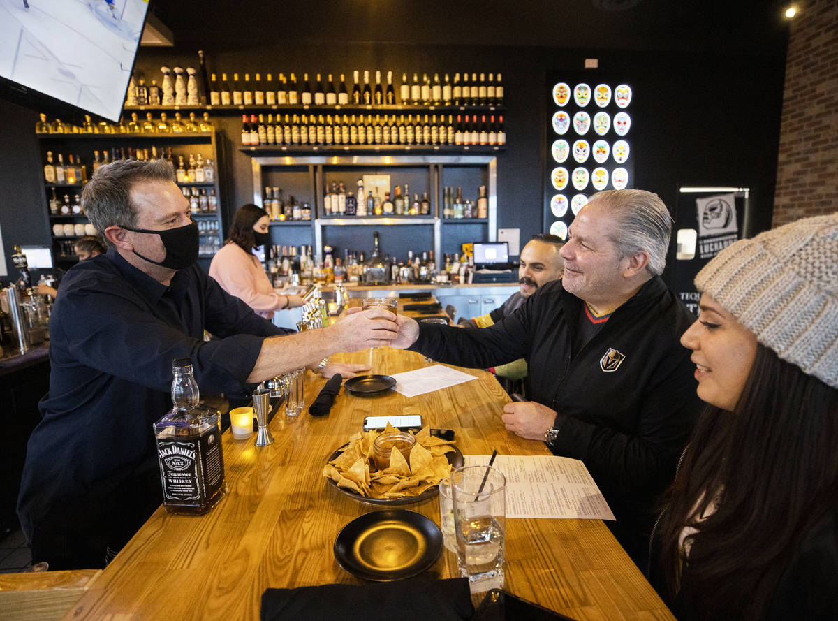 Andy Hooper, left, owner of El Luchador Mexican Kitchen + Cantina, serves a drink to John Engli ...