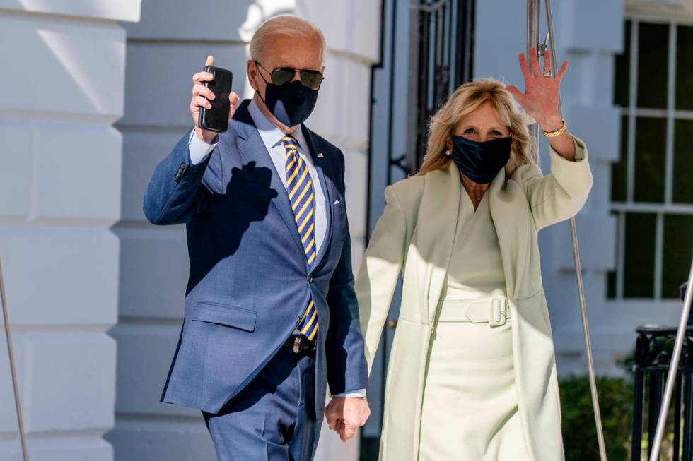 President Joe Biden, accompanied by first lady Jill Biden, waves as he walks to Marine One upon ...