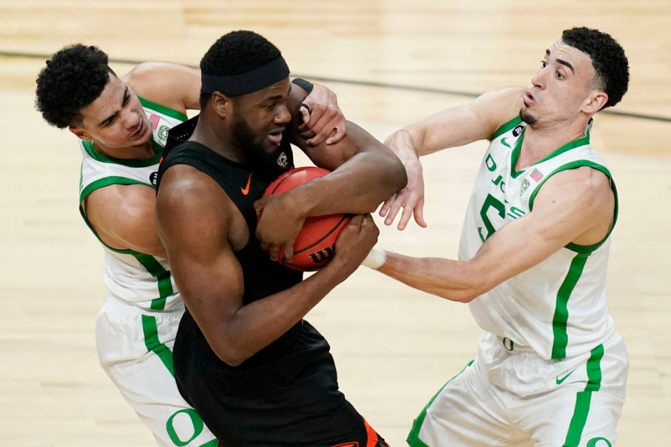 Oregon's Will Richardson, left, and Chris Duarte, right, battle for the ball with Oregon State' ...