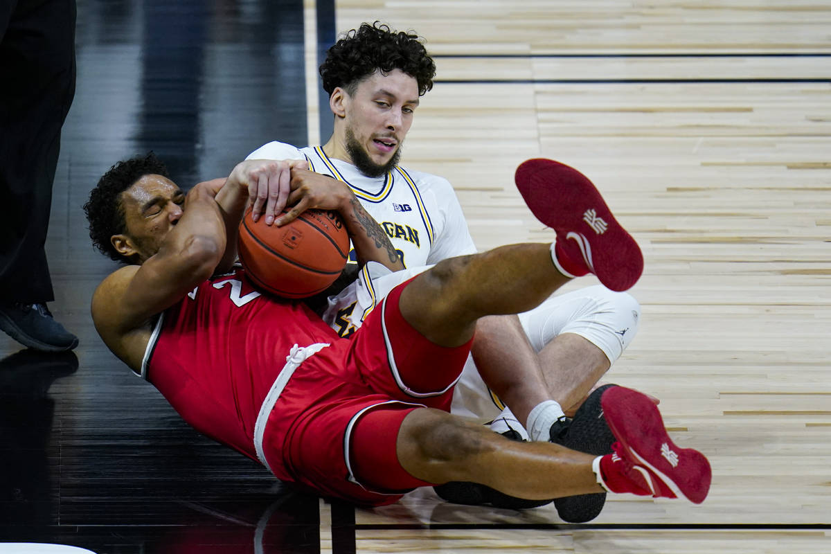 Michigan forward Brandon Johns Jr. (23) and Ohio State guard Musa Jallow (2) fight for a loose ...