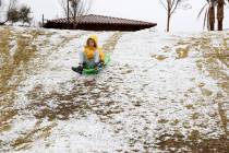 Richard Vergasov, 11, of Las Vegas, takes a sled ride in the snow at Fox Hill Park in Summerlin ...