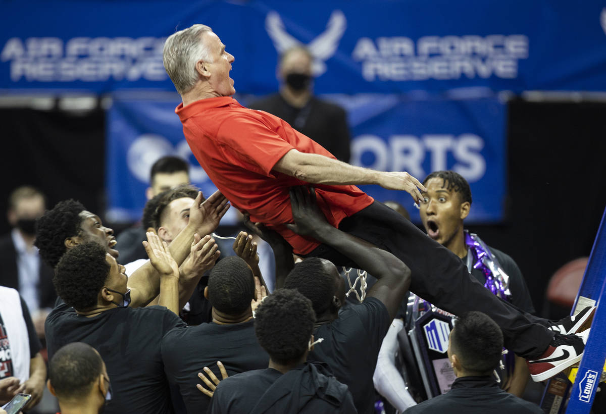 San Diego State Aztecs head coach Brian Dutcher celebrates with a trust fall into his players a ...