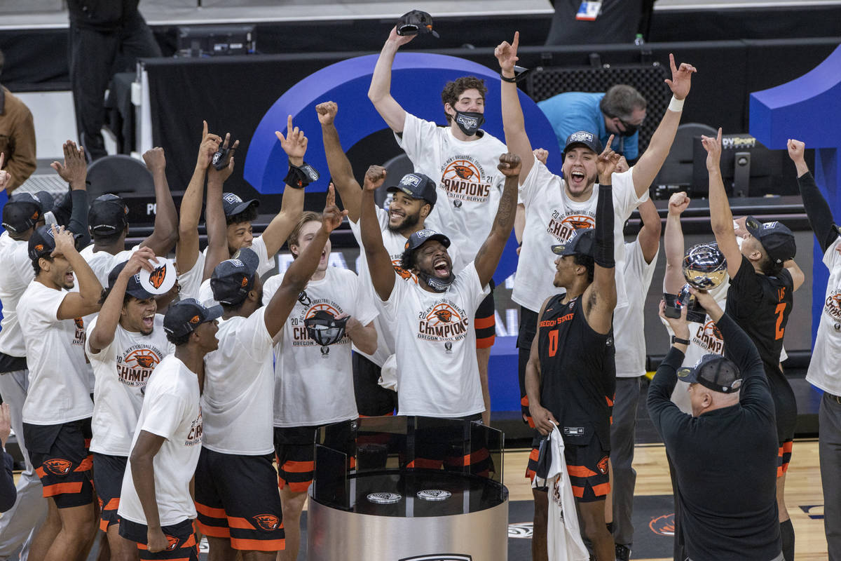 Oregon State Beavers head coach Wayne Tinkle and players celebrate their win with a trophy afte ...