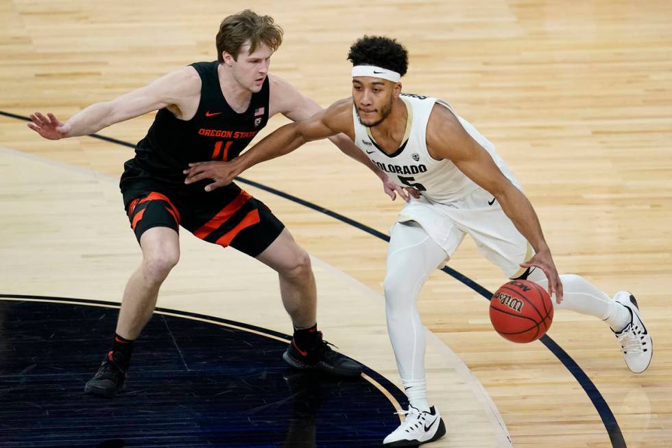 Colorado's D'Shawn Schwartz (5) drives into Oregon State's Zach Reichle (11) during the first h ...