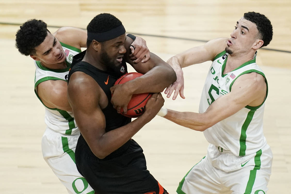 Oregon's Will Richardson, left, and Chris Duarte, right, battle for the ball with Oregon State' ...