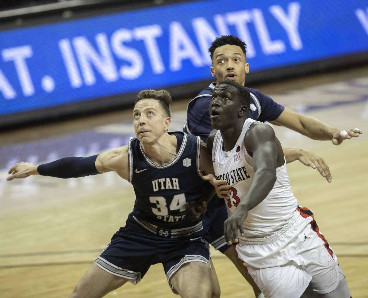 Utah State Aggies forward Justin Bean (34) and Utah State Aggies guard Marco Anthony (44) fight ...