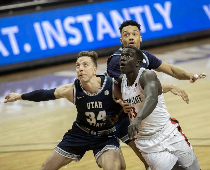 Utah State Aggies forward Justin Bean (34) and Utah State Aggies guard Marco Anthony (44) fight ...