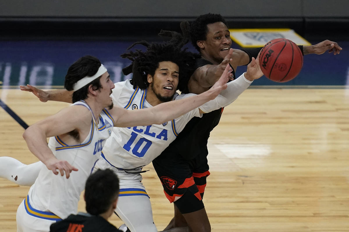 UCLA's Jaime Jaquez Jr., left, Tyger Campbell, center, and Oregon State's Gianni Hunt battle fo ...