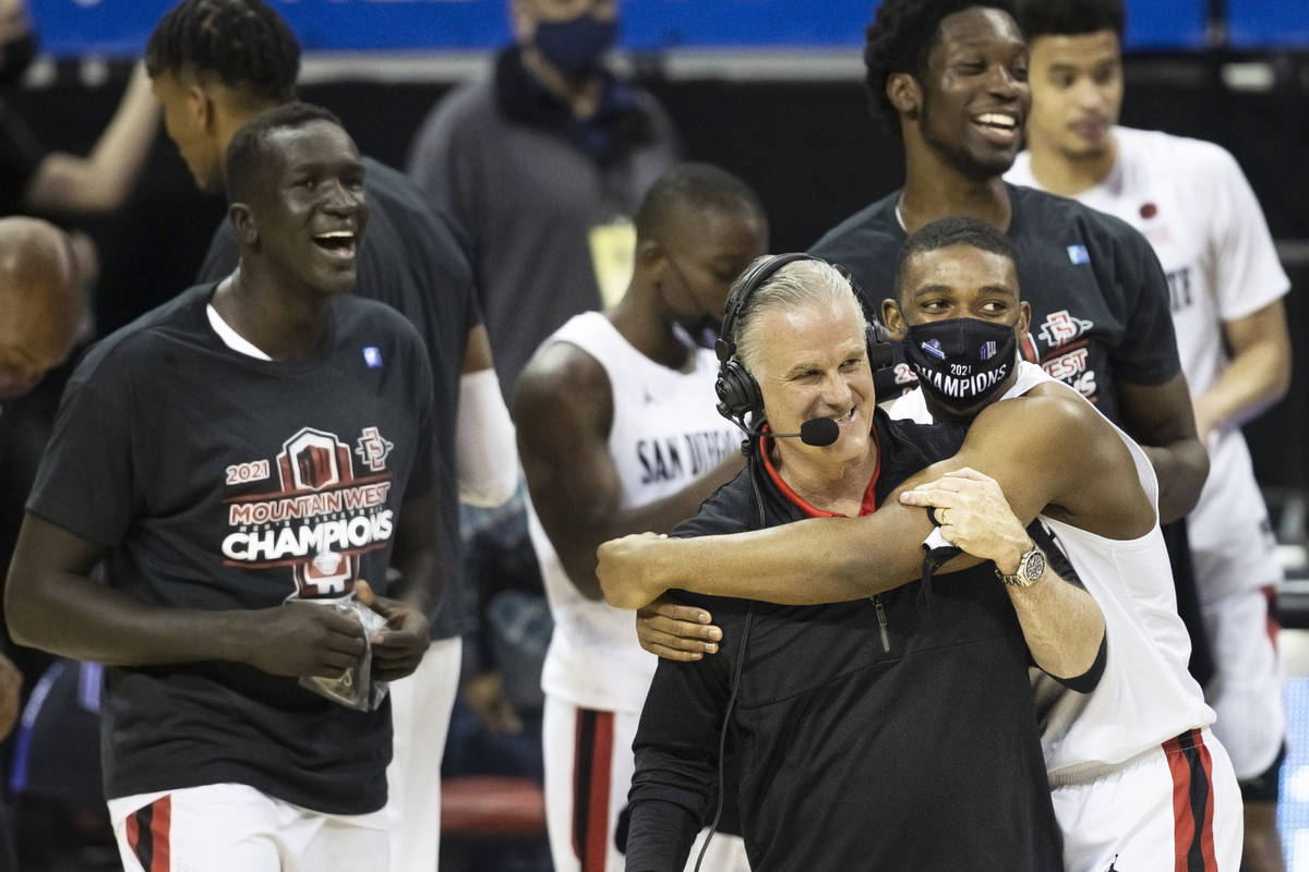 San Diego State Aztec players celebrate with head coach Brian Dutcher, right/front, after winni ...