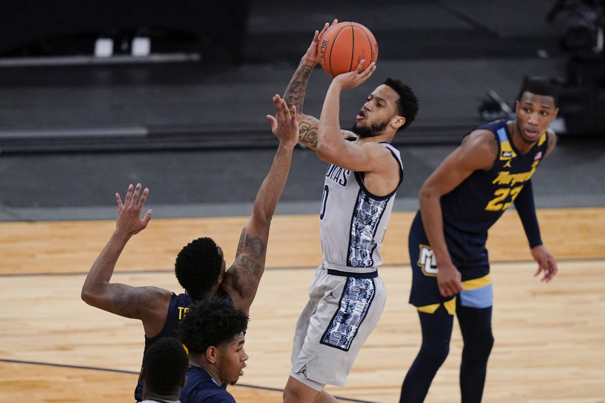 Georgetown's Jahvon Blair, center, shoots over Marquette's Symir Torrence as Jamal Cain, right, ...