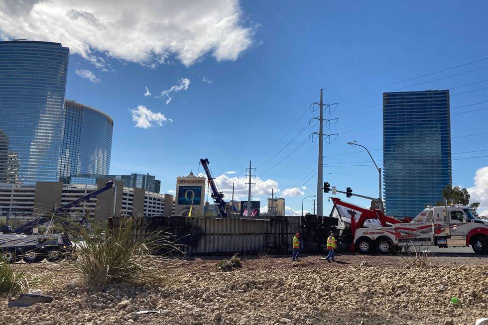 Crews work on an overturned semitractor-trailer Monday, March 15, 2021, on the eastbound Flamin ...