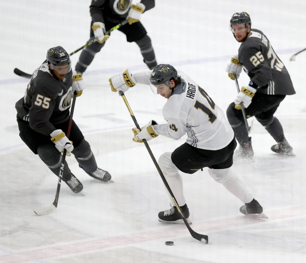 Golden Knights defenseman Nicolas Hague (14) moves the puck between right wing Keegan Kolesar ( ...